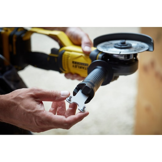 Photo of STANLEY SFMCG400M2K angle grinder with accessory tool attached, shown in use.