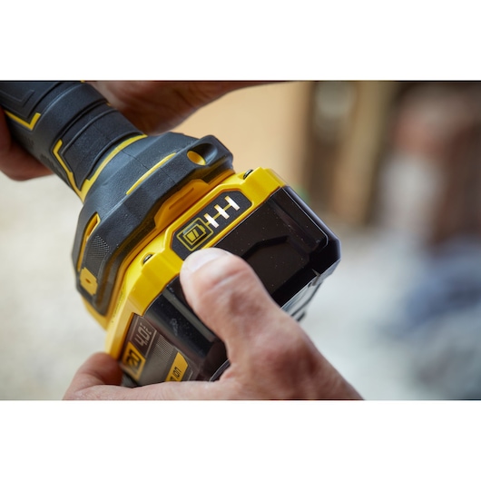 Close-up photo of STANLEY SFMCG400M2K cordless grinder handle and battery being held.