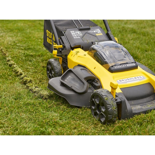 Stanley SFMCMW2651M yellow and black brushless lawn mower close-up on grass, side angle.