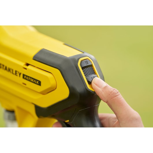 Photo of STANLEY SFMCPC93M1 photography tool, close-up of yellow and black body with finger on settings switch.