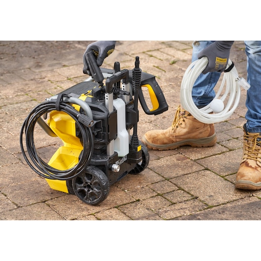 STANLEY SFMCPW1500B pressure washer with hose and accessories, photo of product on outdoor pavement.