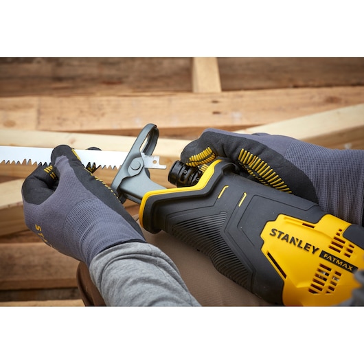 Photo of STANLEY SFMCS300D2K reciprocating saw being adjusted, close-up showing yellow and black tool.