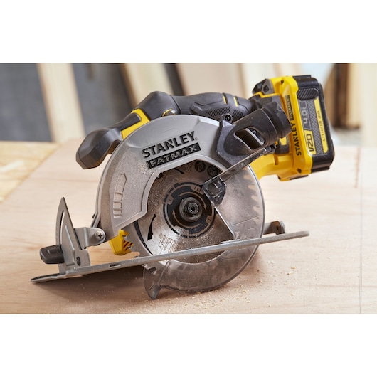 STANLEY SFMCS500M2K cordless circular saw, side angle, with blade cutting wood surface.
