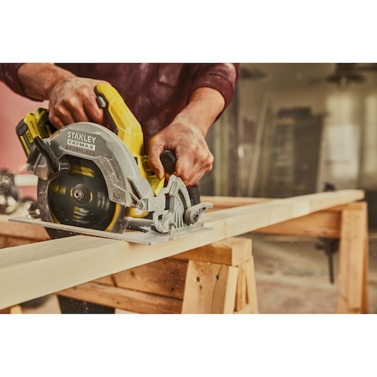 Stanley SFMCS550B circular saw in use cutting wood, close-up in workshop setting.