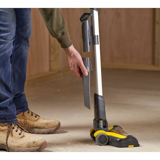 STANLEY SFMCVS001D1 stick vacuum with accessories attached, side angle on concrete floor.