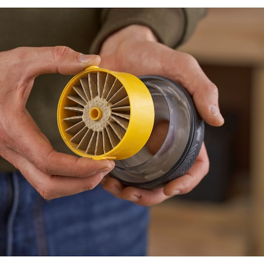 STANLEY SFMCVS001D1 vacuum filter with yellow cover held in hand, close-up, product photography.