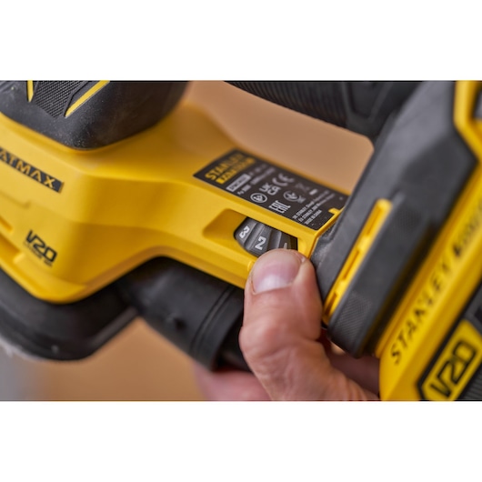 STANLEY SFMCW221B cordless sander close-up, showing speed control switch and ergonomic grip.