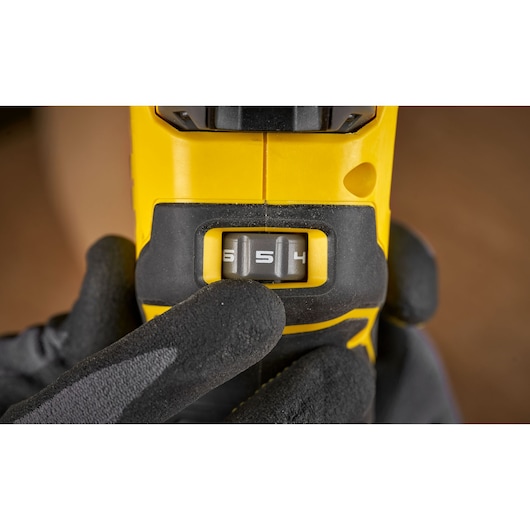 Photo of STANLEY SFMCW400B power tool speed selector switch, close-up with glove-hand adjusting dial.