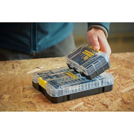 STANLEY STA88558 clear and black organizer case with yellow latch, hand holding removable tray.