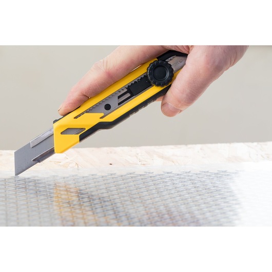 STANLEY STHT10268-0 utility knife in use cutting material, close-up angle.