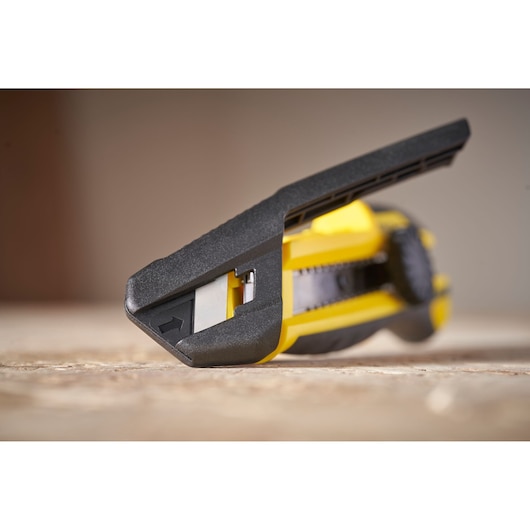 STANLEY STHT10500-0 utility knife close-up, yellow and black, angled view on wood surface.