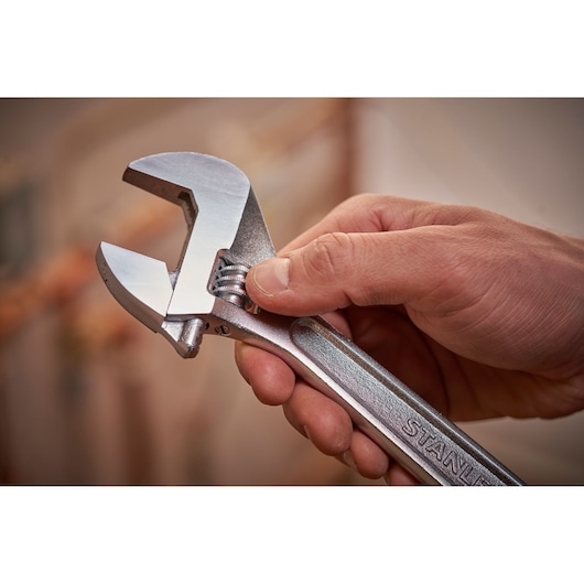 STANLEY STHT13123-0 adjustable wrench held in hand, silver finish, close-up photo.