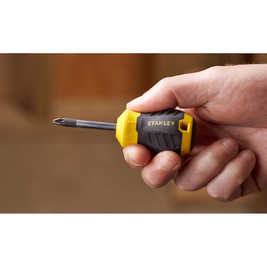Photo of STANLEY STHT16196-0 stubby Phillips screwdriver with yellow and black handle held in hand.
