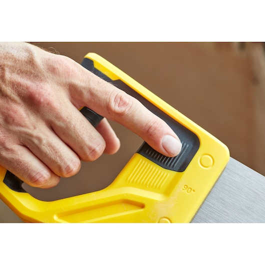 STANLEY STHT20349-1 hand saw, close-up of yellow handle with user adjusting black thumb grip.