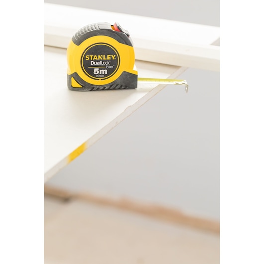 Photo of STANLEY STHT36803-0 5m DualLock tape measure on edge of white surface.