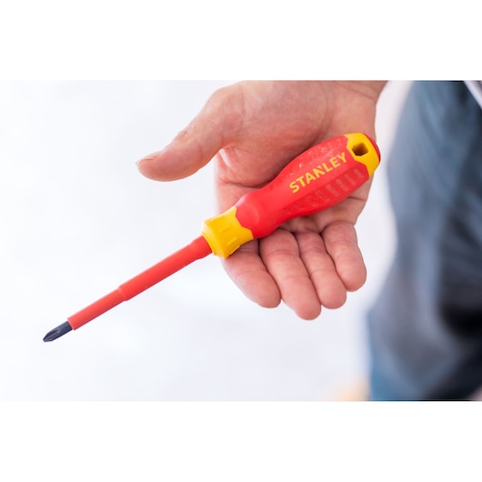 Photo of STANLEY STHT60032-0 insulated screwdriver with red and yellow handle held in hand.