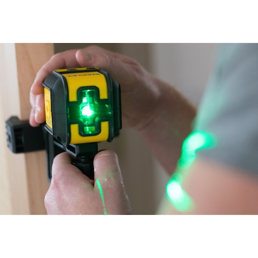 STANLEY STHT77499-1 green beam cross line laser level in use, close-up showing green light projection.