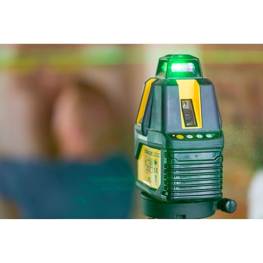 STANLEY STHT77524-1 laser level showing green laser beam in indoor setting, photography close-up.