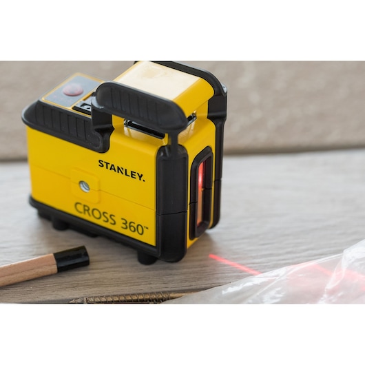 STANLEY STHT77640-1 CROSS 360™ yellow laser level tool on wooden surface side angle.