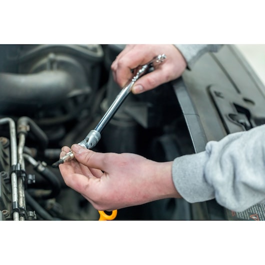STANLEY STHT80888-0 ratchet wrench used on engine part, close-up, product photography.