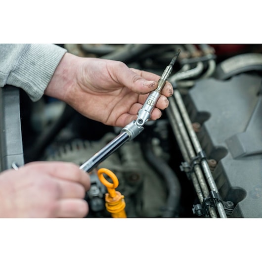 STANLEY STHT81016-0 socket wrench used for automotive repair, close-up of tool in mechanic's hand.