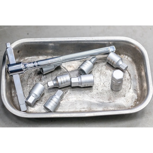 STANLEY STHT81576-0 socket set with ratchet and metric sockets in a metal tray, photographed from above.