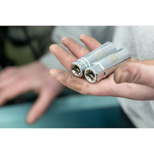 STANLEY STHT81583-0 chrome sockets held in a hand, close-up view, mechanic tool photography.