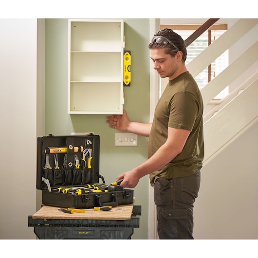 STANLEY STMT72986-1 tool set in open black case, various hand tools visible, used during wall cabinet installation.