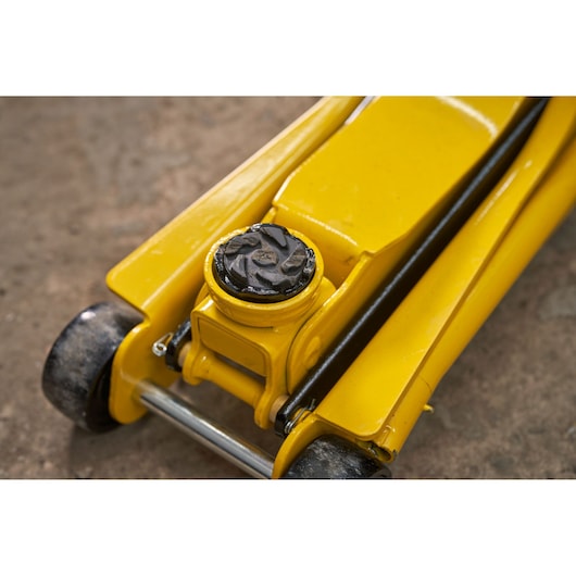 STANLEY STMT81251-1 yellow hydraulic floor jack close-up on concrete surface