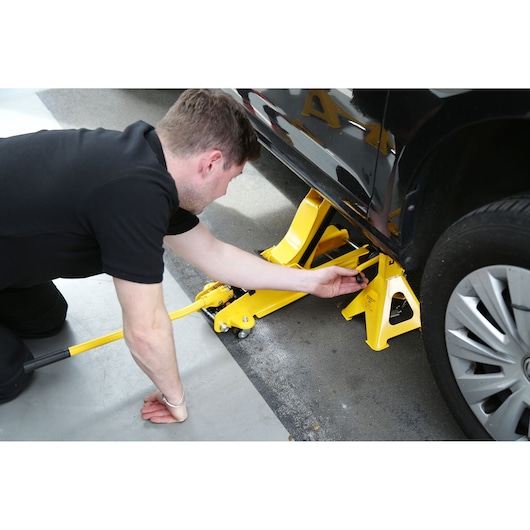 STANLEY STMT81255-1 yellow jack stand and car jack in use under vehicle, side view, automotive accessory.