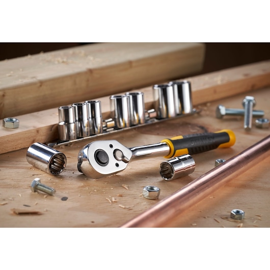 STANLEY STMT82671-0 socket wrench set with ratchet, sockets and nuts on a workshop surface.