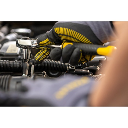 STANLEY STMT82830-1 ratchet wrench being used with gloves in automotive engine context, close-up photo.