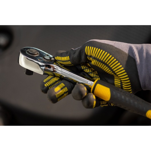 STANLEY STMT82830-1 ratchet wrench held in gloved hand, chrome finish with black and yellow grip.
