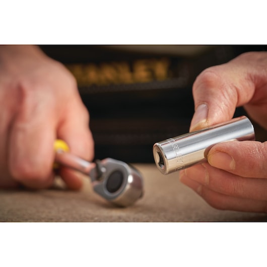 STANLEY STMT86100-0 socket held in hand, with ratchet wrench, close-up photography.