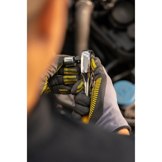 STANLEY STMT86513-0 ratchet wrench in gloved hands, close-up, used for automotive repair.