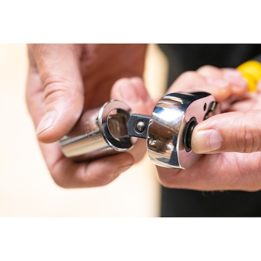 STANLEY STMT86521-0 ratchet and socket close-up held in hand, chrome finish, Photography category.