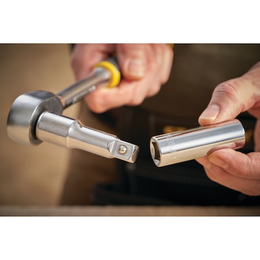 STANLEY STMT88994-0 socket wrench and chrome socket, close-up in hand, showing tool details.
