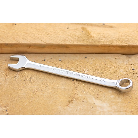 STANLEY STMT95791-0 chrome combination wrench on a wooden surface, product photography.