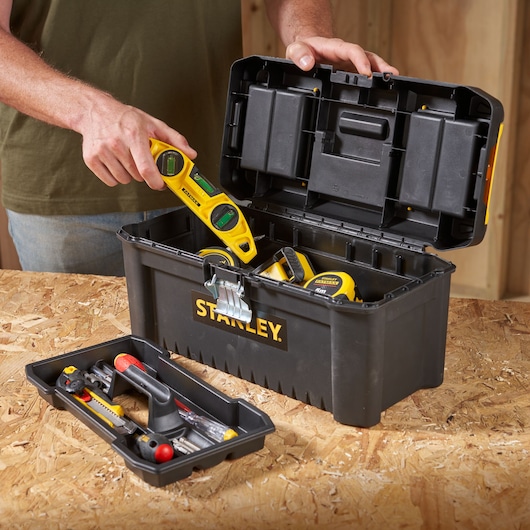 STANLEY STST1-75518-KR black toolbox with tools, open lid, photographed on a workbench.