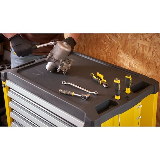 STANLEY STST74306-1 tool chest top with hand tools and person working, angled view, photography