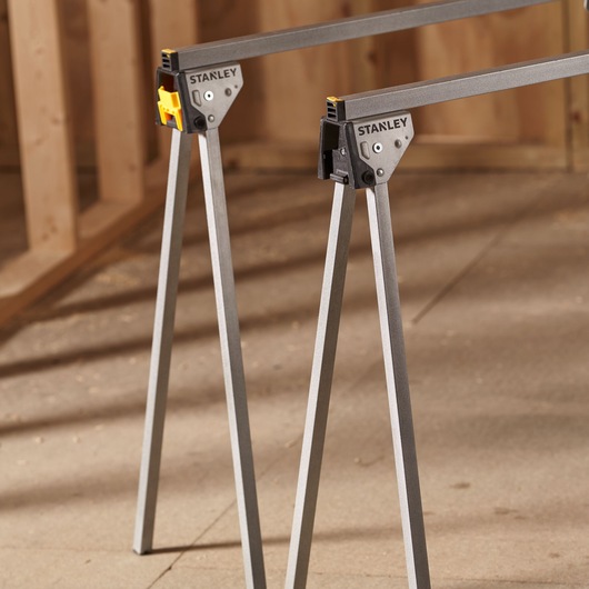 STANLEY STST81337-1 folding saw horse pair with metal legs, angled view, photography in workshop.