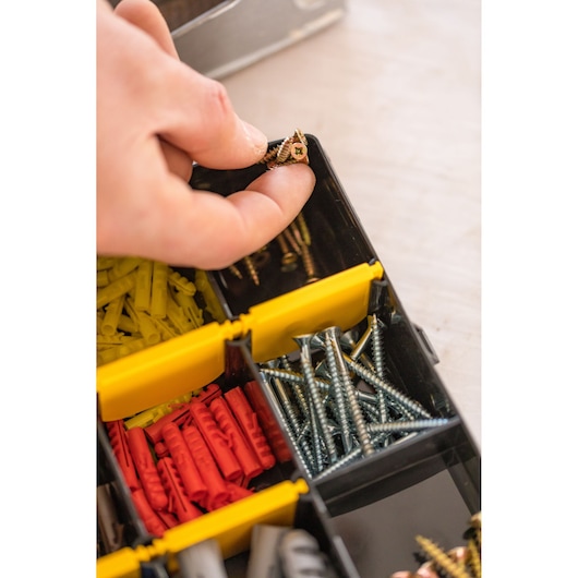 STANLEY STST81681-1 organizer with hand picking screws, assorted wall plugs and fasteners visible.