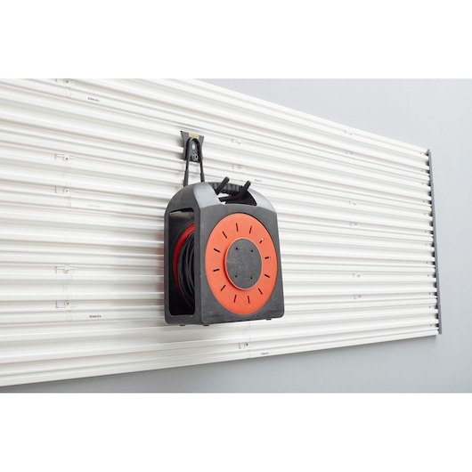 STANLEY STST82608-1 wall-mounted cable reel organizer, black and orange, front angle photo.
