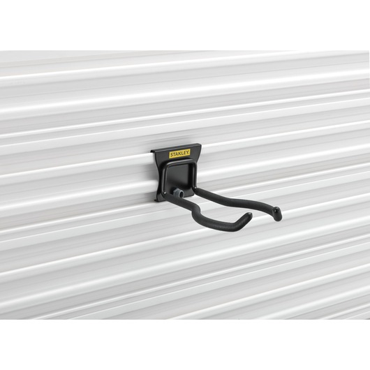 STANLEY STST82609-1 black steel utility hook mounted on white grooved wall, side angle.