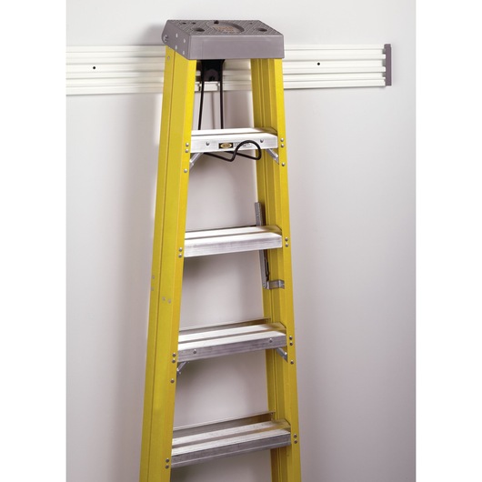 STANLEY STST82614-1 yellow ladder hanging on wall-mounted rack, front angle photo.