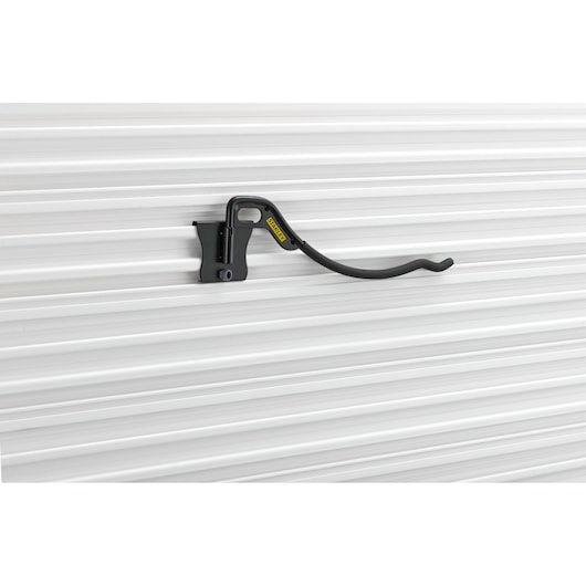 Photo of STANLEY STST82615-1 black curved wall hook mounted on ribbed white wall, side angle.