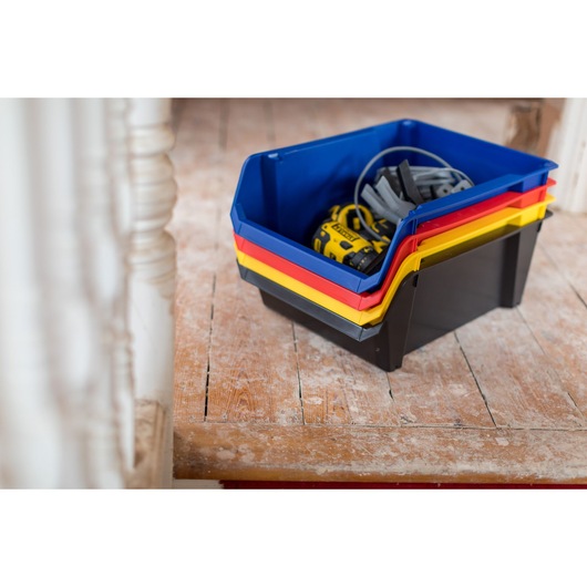 STANLEY STST82746-1 stackable storage bins in blue, red, yellow, and black holding tools, photographed indoors.
